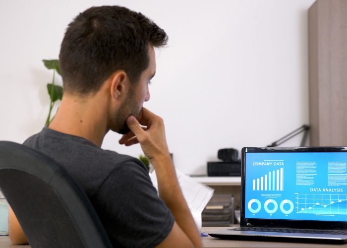 Business man with beard working hard at his desk in the office. Motivated young man .